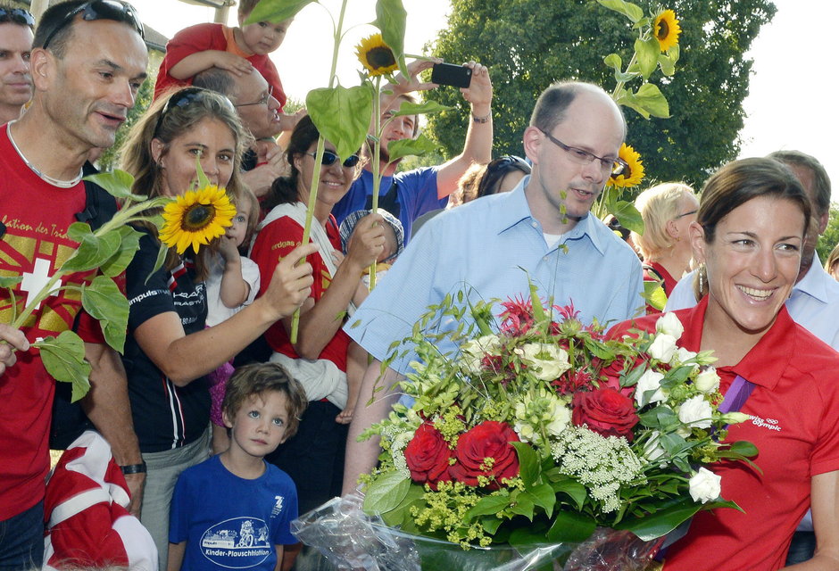 Zu einem solchen  Empfang gehört ein grösser Blumenstrauss: Nicola Spirig im Blumenmeer in Winkel ZH. (13. August 2012)