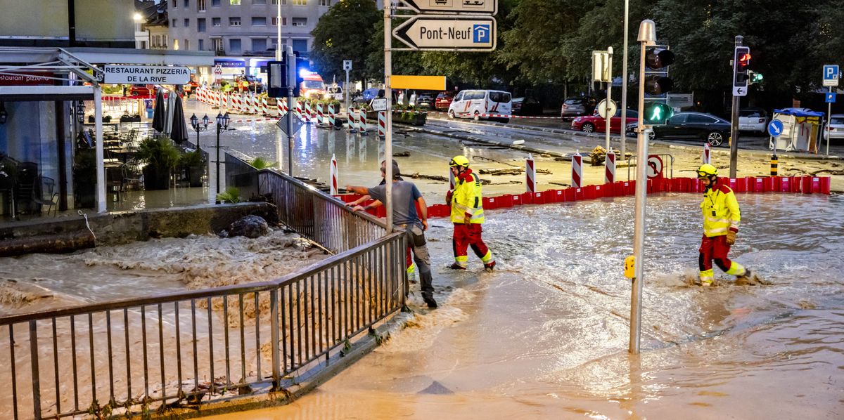 Des pompiers constatent le débordement de la rivière la Morges sur une route suite à un orage qui a entraîné une importante inondation dans le centre-ville le mardi 25 juin 2024 à Morges. (KEYSTONE/Laurent Gillieron)