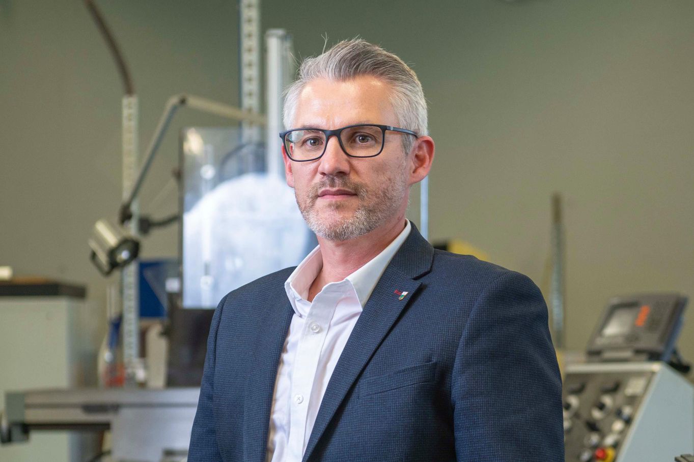 Cédric Roten, en costume, dans un environnement industriel, annonce sa démission. Photo prise à Sainte-Croix.