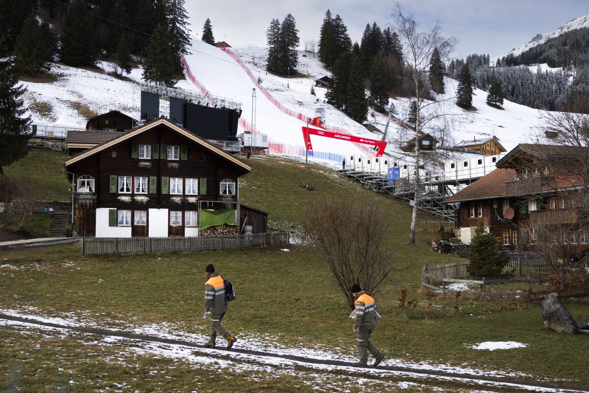 Zwei Mitglieder des Zivilschutzes vor dem praeparierten Zielhang und Zielraum des Ski Weltcuprennens am Chuenisbaergli, am Donnerstag, 4. Januar 2024, in Adelboden. Am kommenden Wochenende sind ein Riesenslalom- und ein Slalomrennenn auf dem Hang am Chuenisbaergli geplant. (KEYSTONE/Peter Klaunzer)