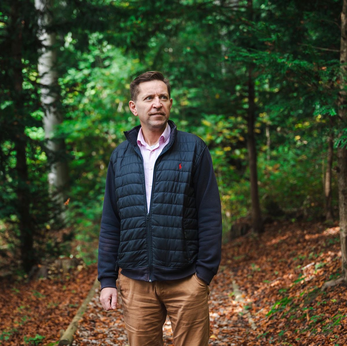 Laurent Vilain, pasteur à Corsier-sur-Vevey, se promène dans une forêt verdoyante.
