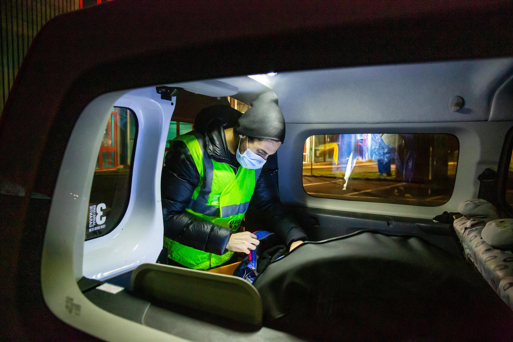 Genève, le 4 février 2021. Le véhicule du Service social de la Ville de Genève permet d’emporter de la nourriture, des boissons chaudes et de ramener celles et ceux qui le souhaitent jusqu’aux abris de Châtelaine ou de Richemont. Oscar prépare les rations de nourriture avant de rejoindre l’adresse occupée de nuit par un groupe de sans-abri. 