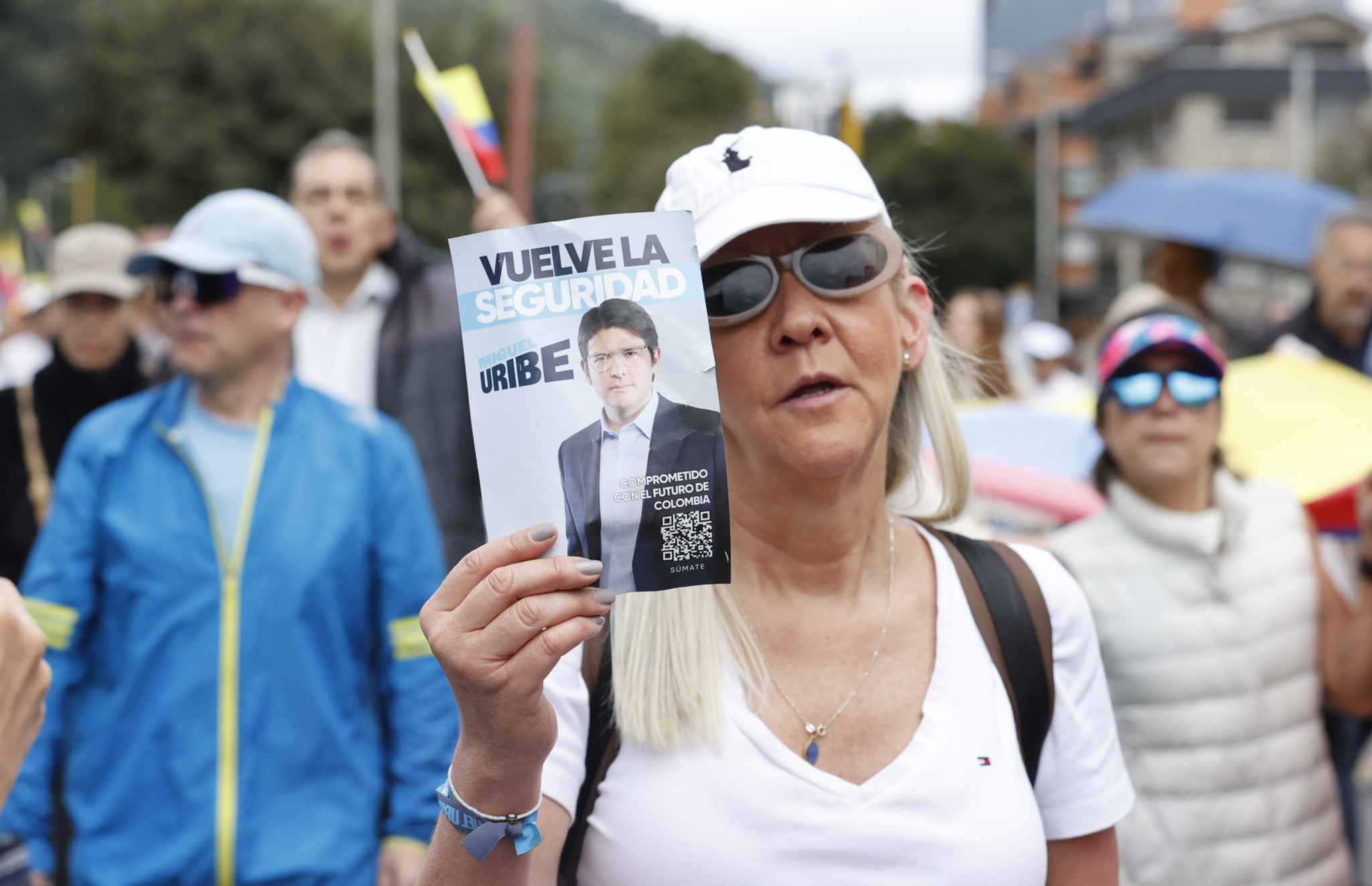 Teilnehmer der Friedensdemonstration in Bogota halten Flyer mit der Aufschrift ’Vuelve la Seguridad Uribe’ zur Unterstützung von Senator Miguel Uribe Turbay, 8. Juni 2025.