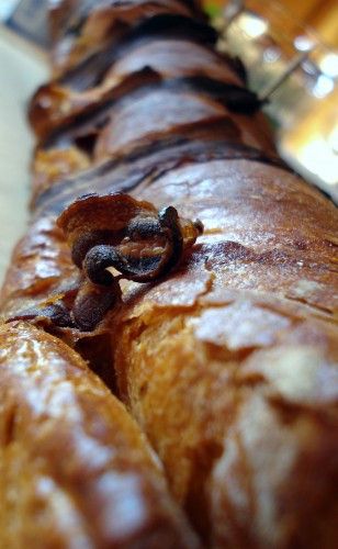 Un gros plan d'une baguette de pain croustillant avec des morceaux de croûte bien dorée.