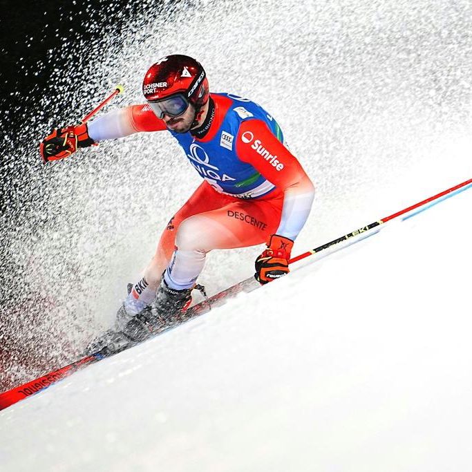 Loic Meillard, skieur suisse, lors du premier tour du slalom géant masculin à Schladming, Autriche, le 28 janvier 2025, générant une gerbe de neige derrière lui.