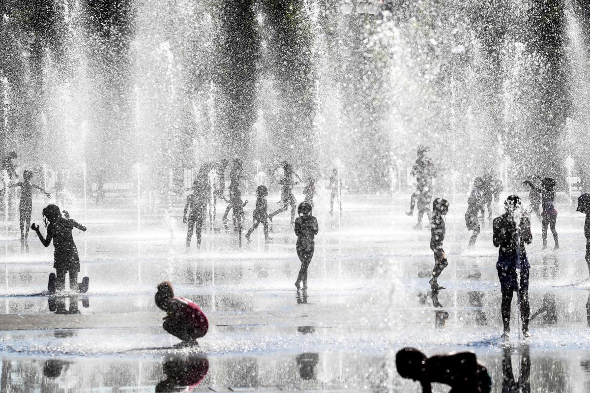 (FILES) Children play under water jets as they cool off in fountains during a heatwave in the French riviera city of Nice, on June 24, 2020. After an initial spell of scorching temperatures in France at the end of July and the beginning of the month, another heatwave is on the cards for the weekend and the end of the Olympic Games, with temperatures likely to reach, or even exceed, 40°C in the south-west, Meteo-France announced on August 8, 2024. (Photo by VALERY HACHE / AFP)