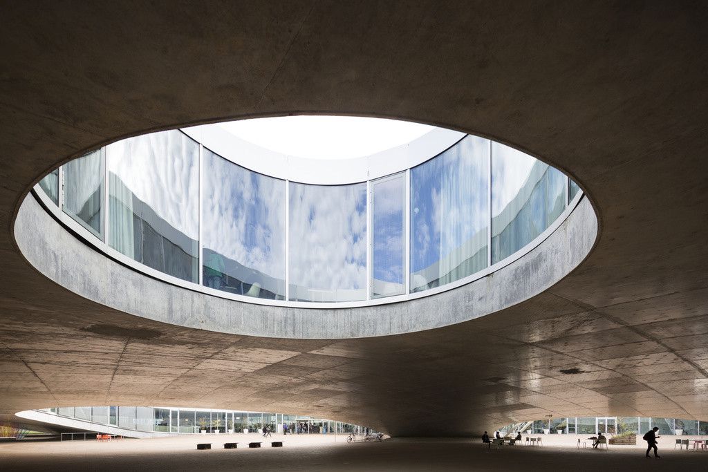 Le Rolex Learning Center de l'EPFL à Lausanne, conçu par le cabinet d'architecture japonais SANAA, vu depuis en dessous d'une ouverture circulaire dans son toit.