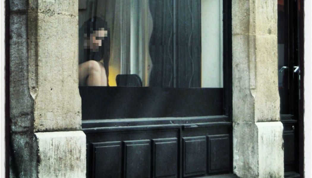 Une prostituée attend un client dans une vitrine des Pâquis.