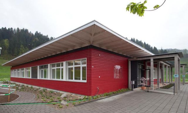 Ein Farbtupfer in der Landschaft: Der Pavillon der Stiftung Integration hebt sich mit seinem dezenten Rot von der grünen Umgebung ab.