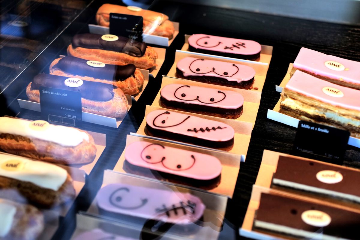 Éclairs décorés au glaçage rose avec des dessins symbolisant la sensibilisation au cancer du sein dans la boulangerie Pouly à Genève.