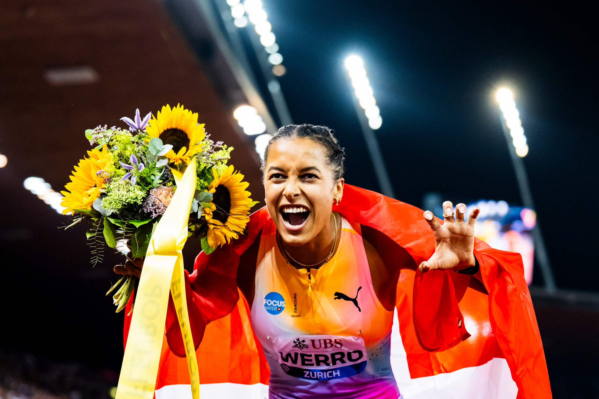 Audrey Werro feiert mit Schweizer Fahne und Blumenstrauss ihren Weltrekord über 800 m an der Weltklasse Zürich im Letzigrund.