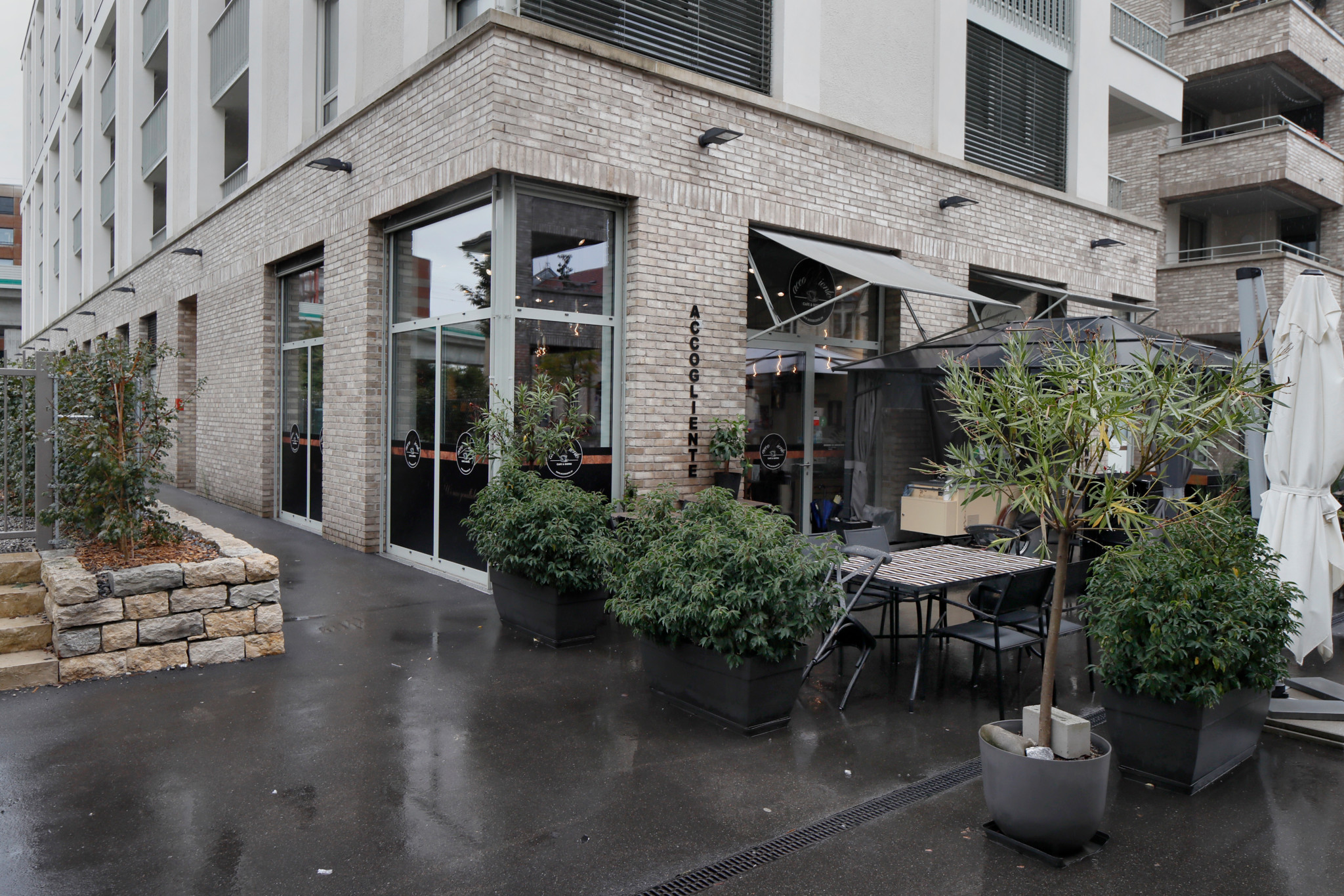 Eingang des Ristorante Accogliente in Wallisellen, ZH mit Pflanzen und Terrassenbereich.