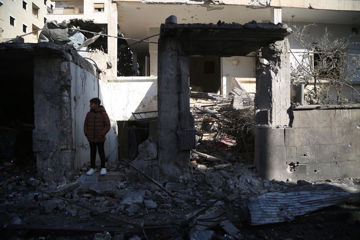 Une personne se tient parmi les débris d’un bâtiment endommagé par une frappe aérienne à Idlib, en Syrie, décembre 2024.