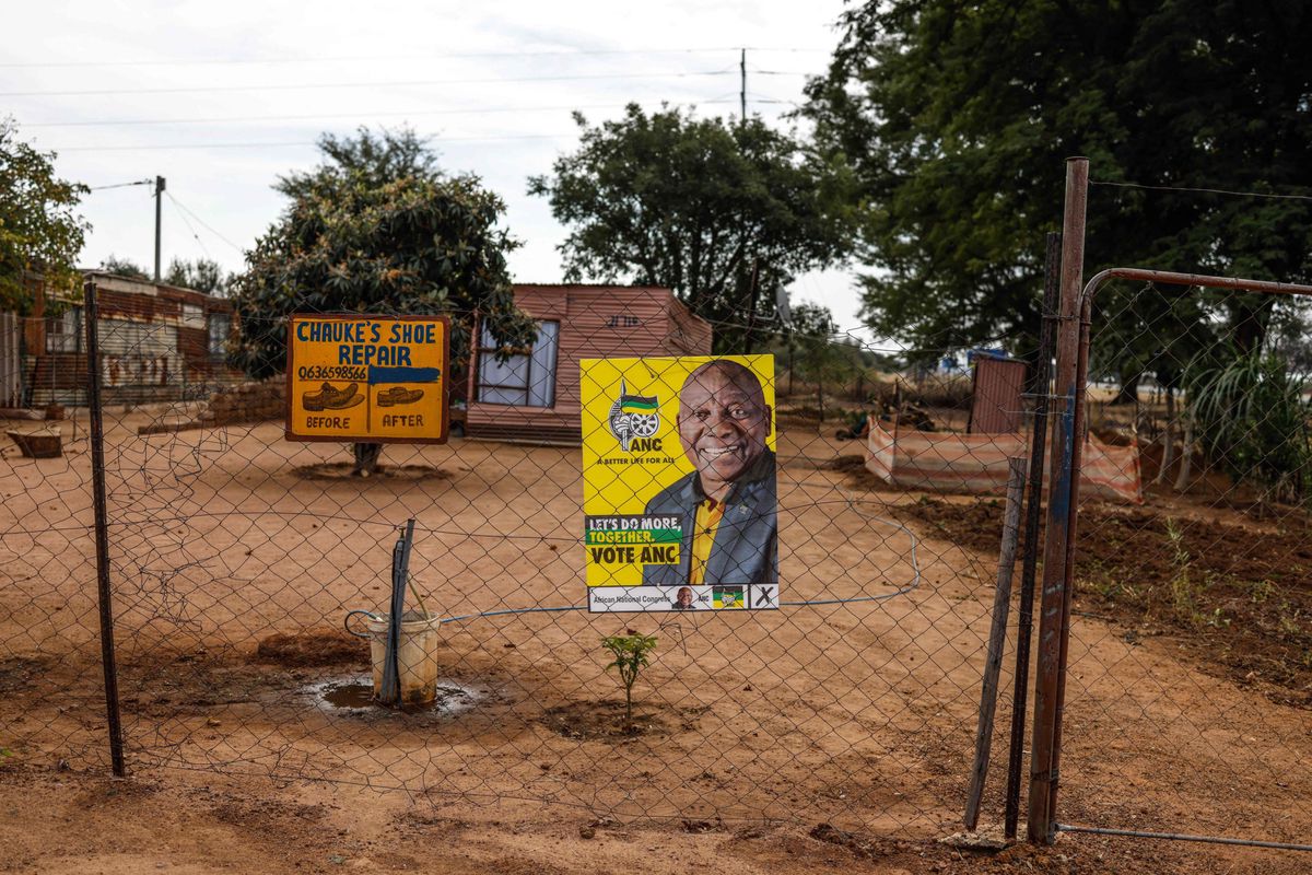 An electoral poster of African National Congress (ANC) leader and South African President Cyril Ramaphosa is seen on a fence at a house in Hammanskraal on May 28, 2024, a day before the South African elections. (Photo by PAUL BOTES / AFP)