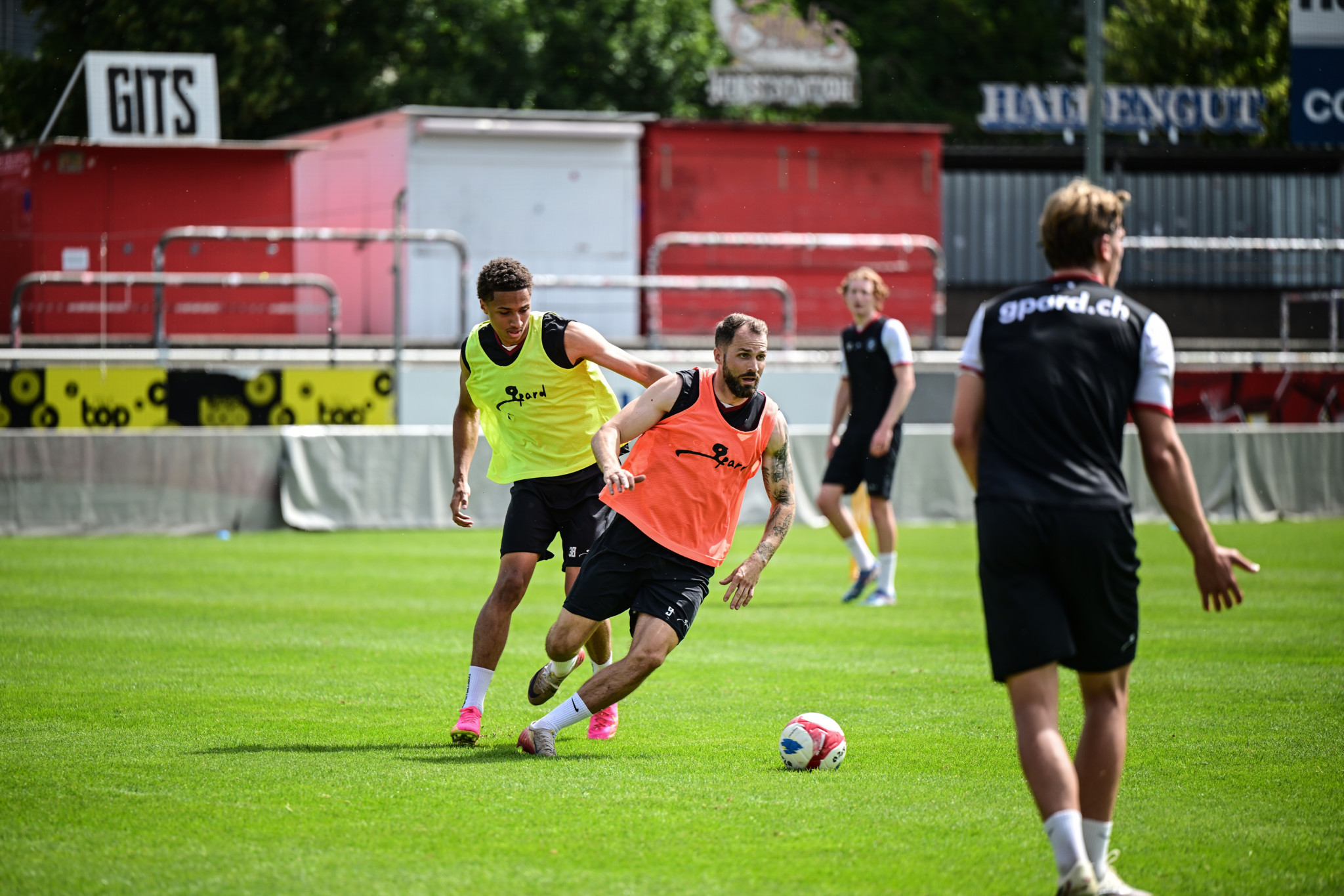 Roman Buess beim Trainingsstart des FC Winterthur auf der Schützenwiese – Spieler in gelben und orangen Leibchen dribbeln mit dem Ball.