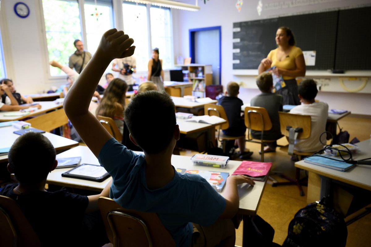 Un eleve de 6eme annee primaire, 6P, enfant de 9-10 ans, pose une question en levant la main lors d'un cours d'education numerique au sujet des ecrans et des pratiques numeriques ce lundi 12 juin 2023 a l'ecole du college intercommunal de l'Etablissement primaire Villars-le-Terroir - Poliez-Pittet a Poliez-Pittet dans le canton de Vaud. (KEYSTONE/Laurent Gillieron)