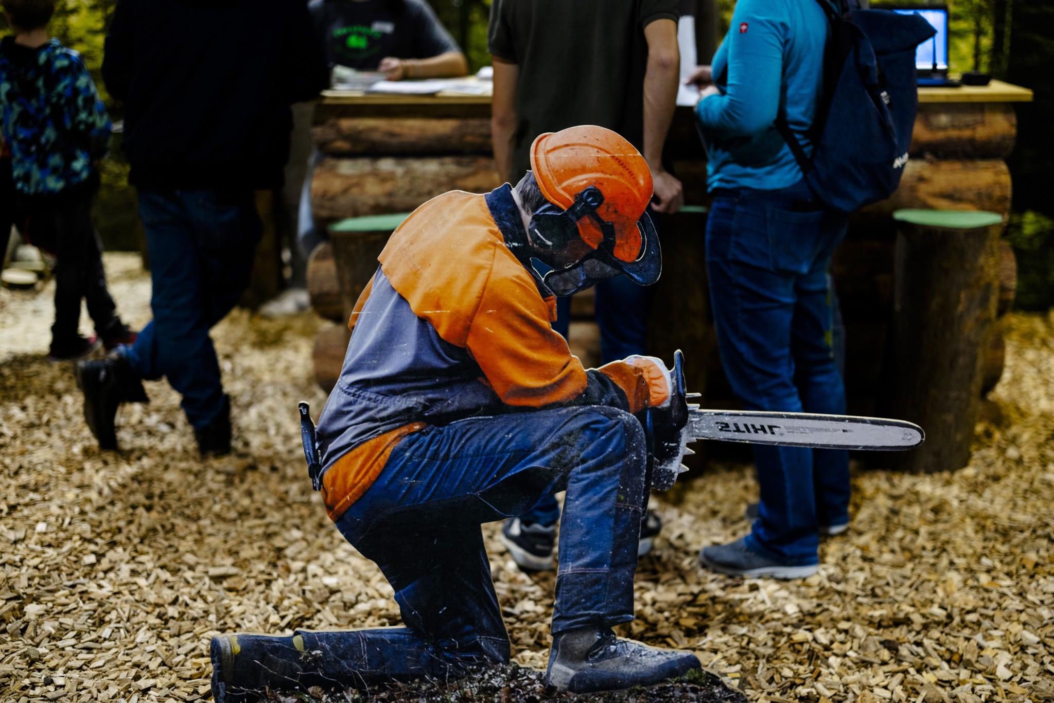 Kartonfigur eines Forstarbeiters mit Motorsäge und orangem Schutzhelm an der Berufsmesse Zürich 2023.