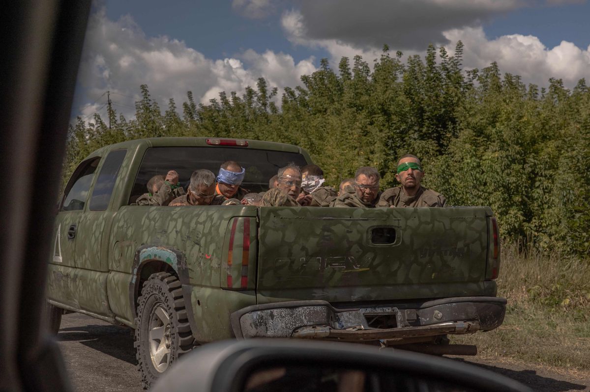 Un véhicule militaire ukrainien transporte des hommes aux yeux bandés en uniformes militaires russes depuis la direction de la frontière avec la Russie, dans la région de Soumy, le 13 août 2024.