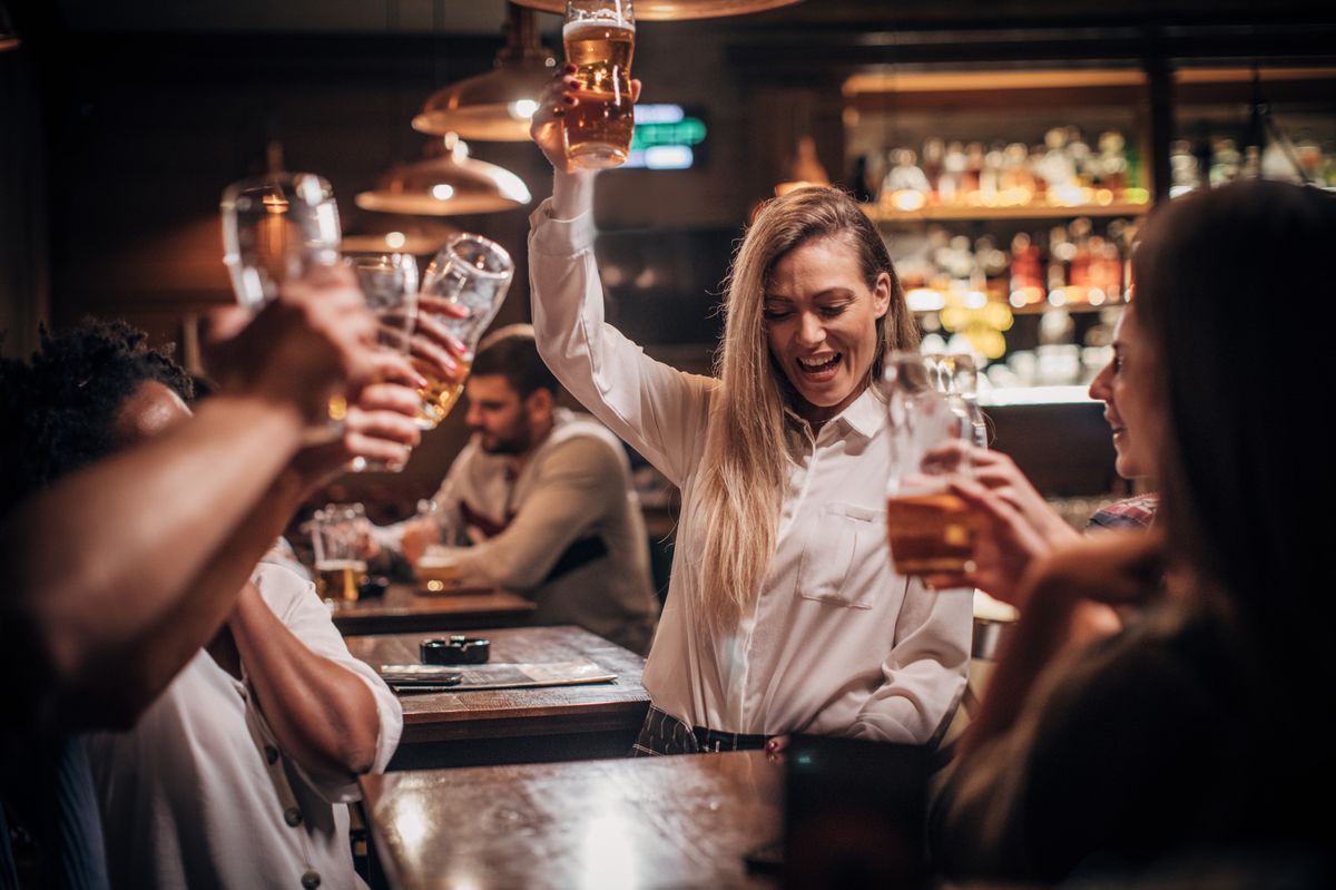 Groupe d'amis s'amusant et buvant de la bière dans un pub