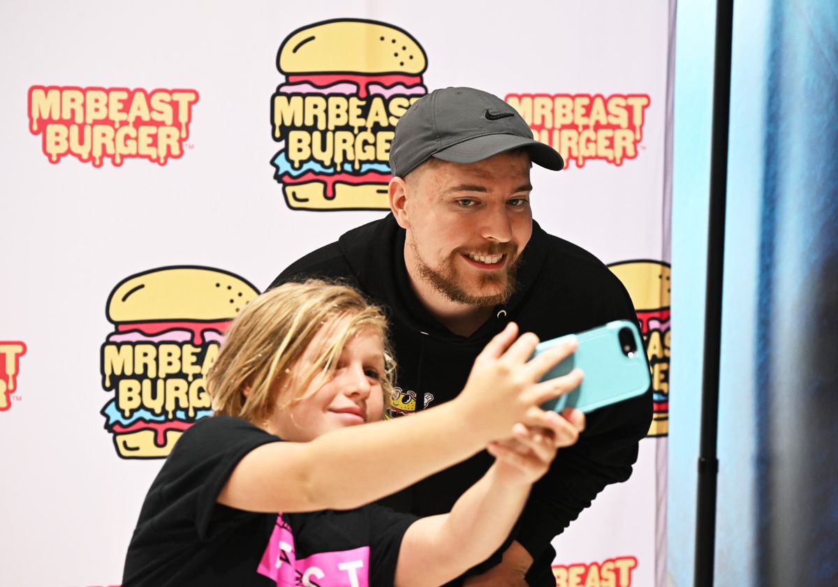EAST RUTHERFORD, NEW JERSEY - SEPTEMBER 04: Global YouTube star MrBeast (R) poses with fan at the launch of the first physical MrBeast Burger Restaurant at American Dream on September 4, 2022 in East Rutherford, New Jersey. (Photo by Dave Kotinsky/Getty Images for MrBeast Burger)
