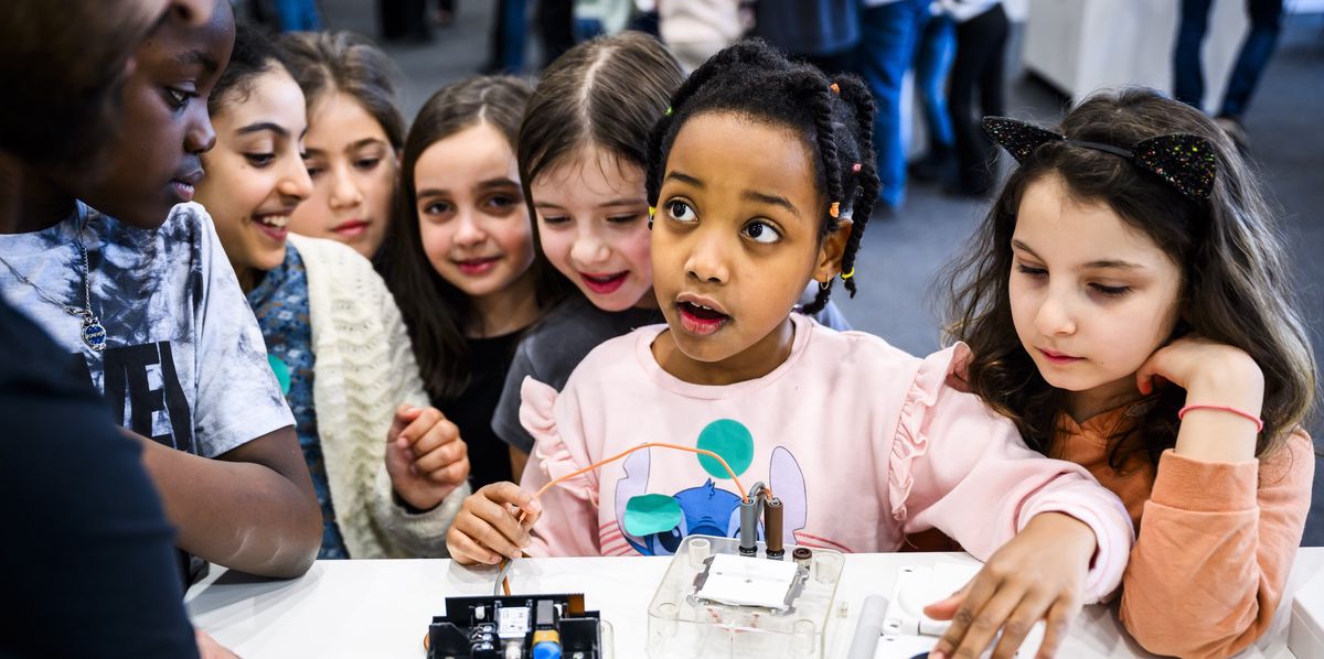 Des enfants decouvrent un stand avec des composants électroniques.