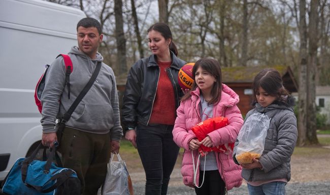 Arthur, réfugié ukrainien, sa femme Viktoria et leurs jeunes filles devant le mobile-home temporaire du camping de La Ville-aux-Dames dans le centre de la France, le 31 mars 2022.