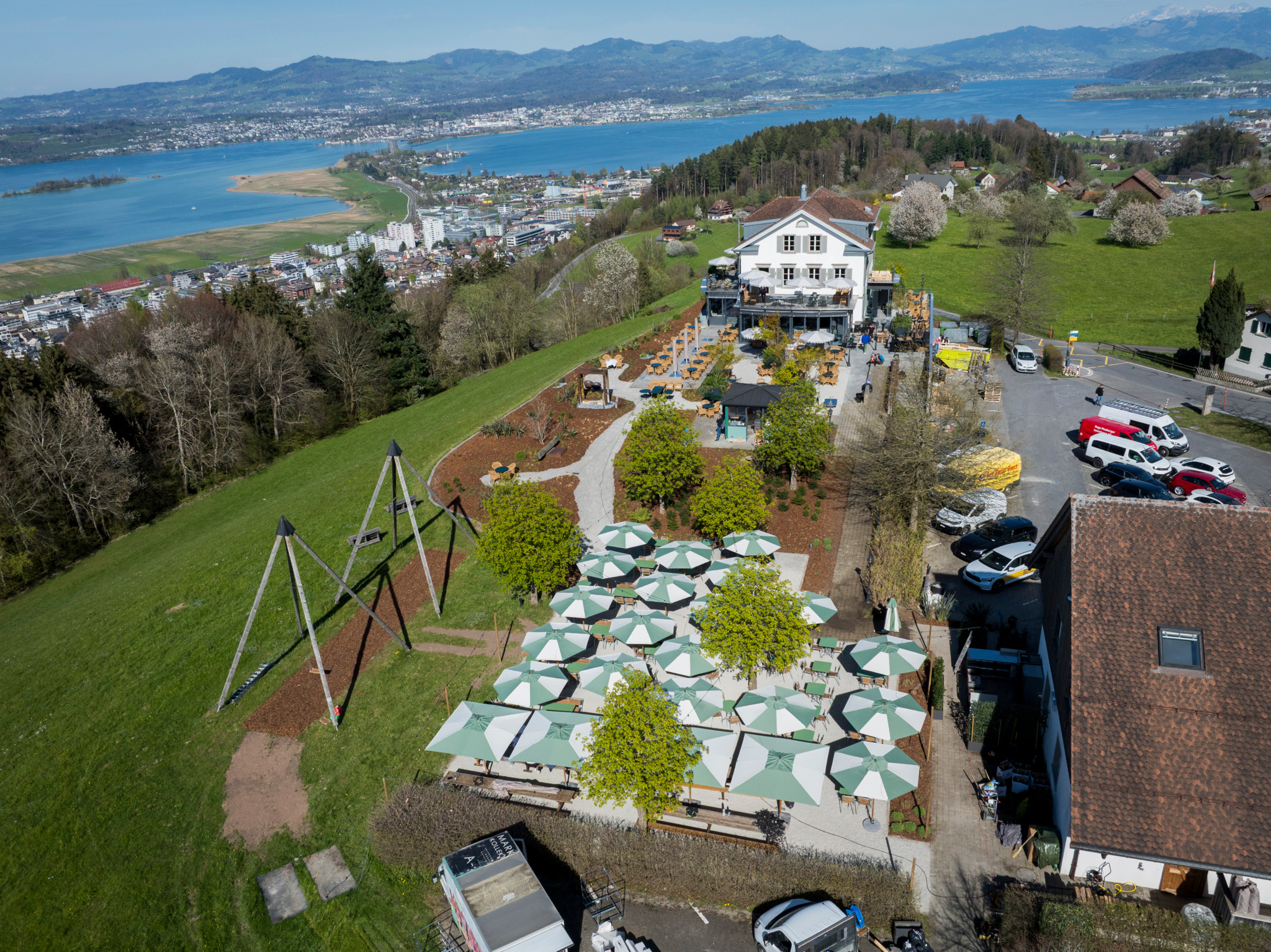 Luftaufnahme des Restaurants Luegeten in Freienbach mit Sonnenschirmen auf der Terrasse, kurz vor der Wiedereröffnung durch Michel Peclard, Zürichsee im Hintergrund.