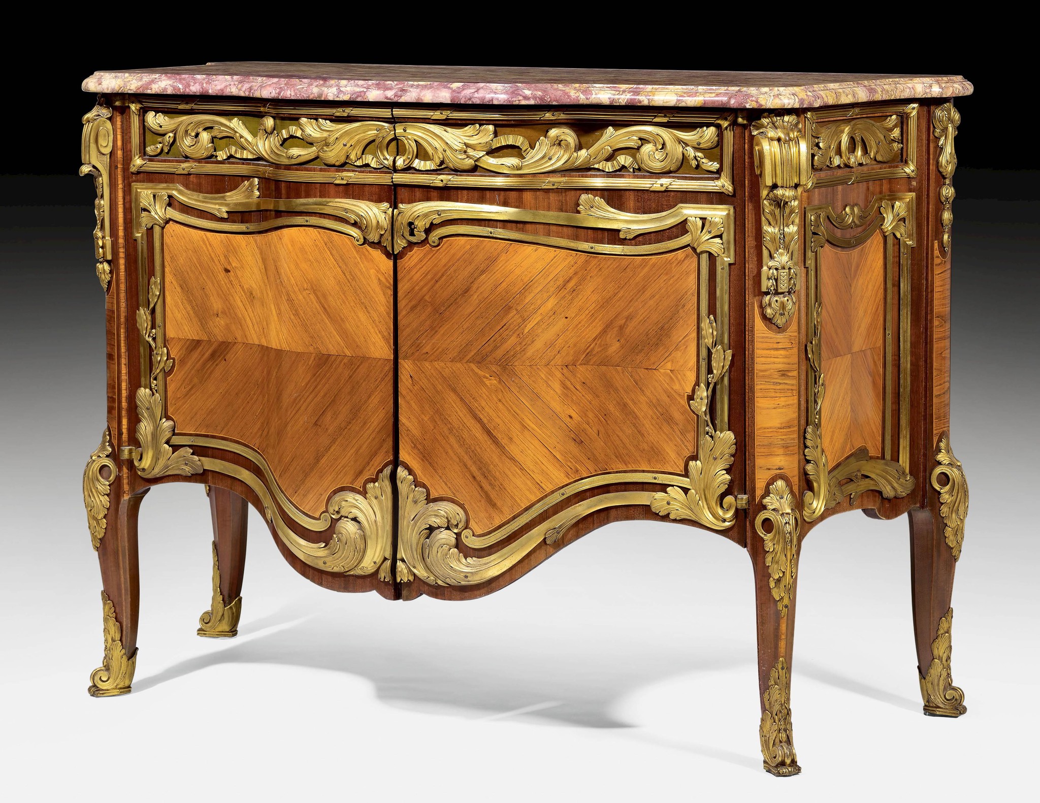 Commode en bois avec des détails dorés et un dessus en marbre rose, style ancien.