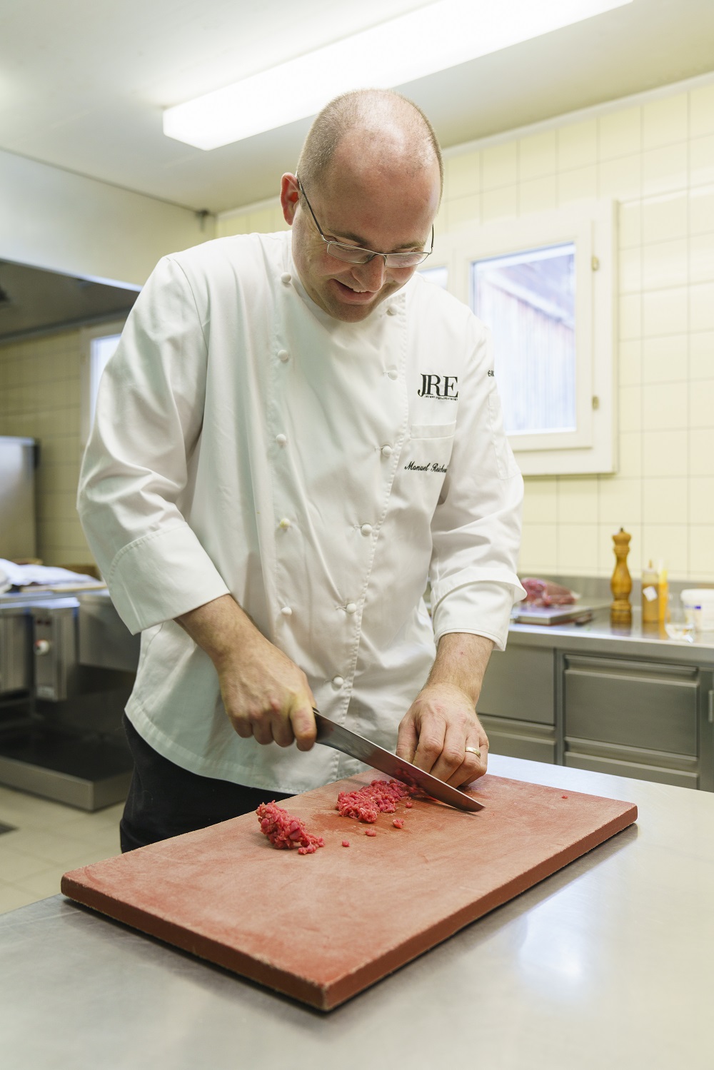 Zuerst schneidet er Scheiben, dann kleine Würfel: Manuel Reichenbach in seiner Küche. Foto: Daniel Martinek