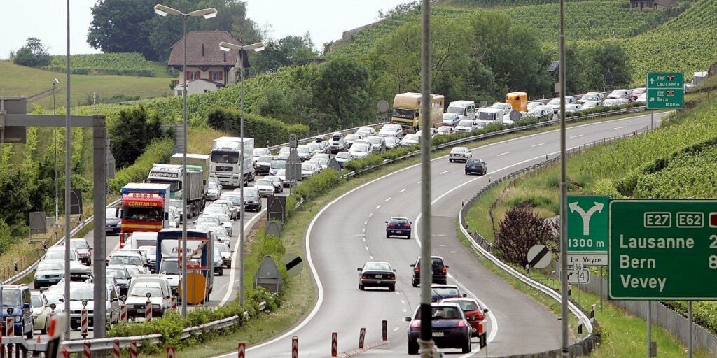 Embouteillage sur une autoroute rurale avec des panneaux indiquant les directions vers Lausanne, Bern et Vevey.