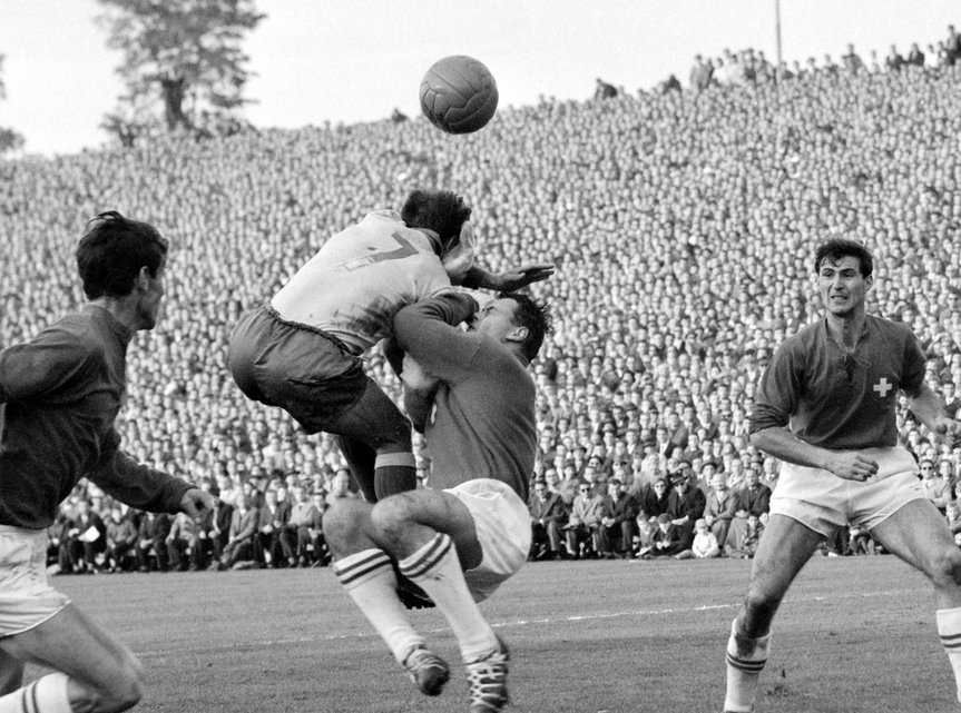 1961 Kein Schnickschnack beim WM-Qualifikationsspiel in Bern gegen Schweden (3:2). Einfach rot und weiss – und ein geschnürten Kragen. Im Bild sehen wir, wie sich der Schweizer Goalie Charly Elsener im Wankdorfstadion wagehalsig ins Getümmel wirft.