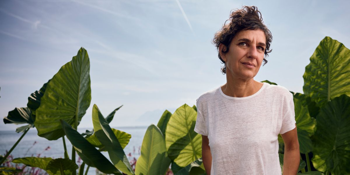 Gabriella Zalapì au Festival Les livres sur les quais, debout devant des plantes avec vue sur le lac Léman en arrière-plan, pour la sortie de son roman Ilaria.