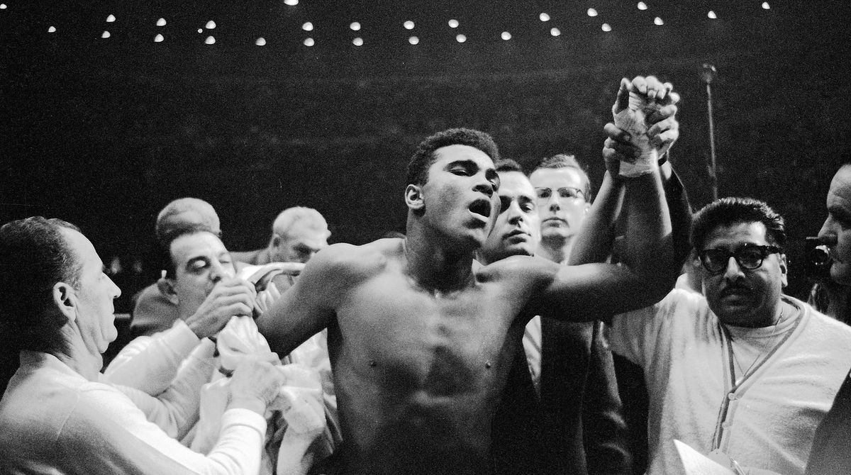 Mohamed Ali, sous le nom de Cassius Clay, lève le poing, après sa victoire au 4e round sur Archie Moore, par K-O technique, à Los Angeles, le 15 novembre 1962. Le jeune boxeur de 20 ans avait prédit avant le combat qu'il stopperait son adversaire à la 4e reprise.