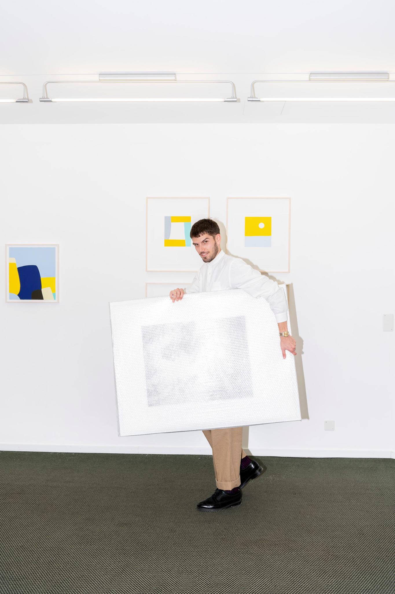 David Khalat, Leiter Edition VFO, mit einer eingepackten Heliogravüre von Julia Steiner, im Hintergrund Arbeiten von Federico Herrero.