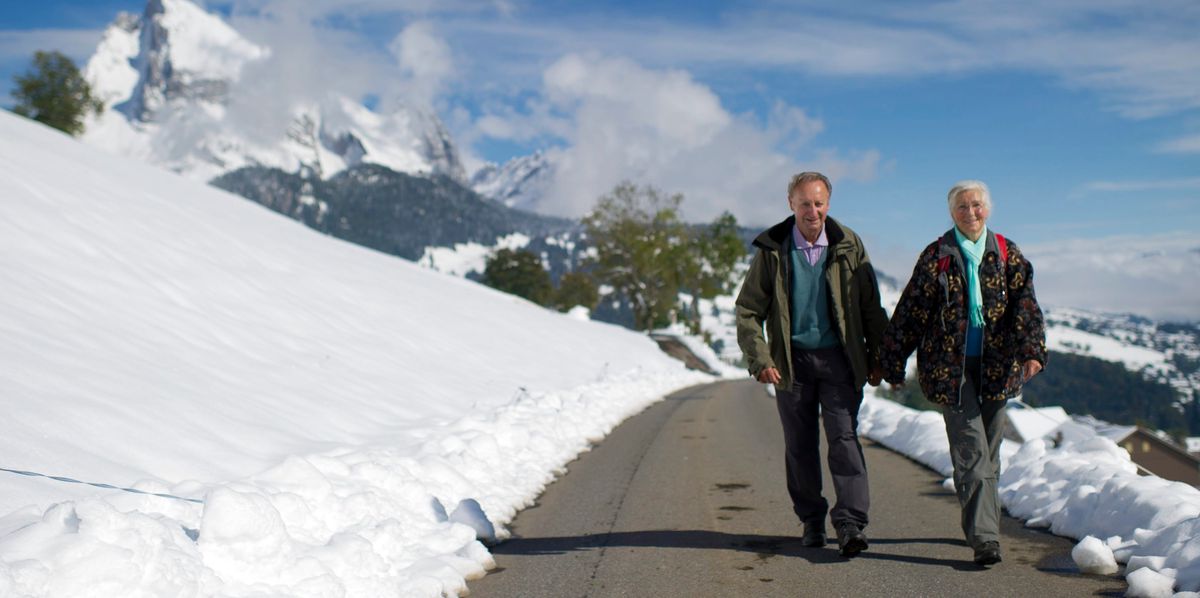 Zwei Wanderer unterwegs im verschneiten Togenburg, im Hintergrund die Churfirsten, aufgenommen am Freitag, 11. Oktober 2013, in Unterwasser (Gemeinde Wildhaus Alt-St. Johann). (KEYSTONE/Gian Ehrenzeller)