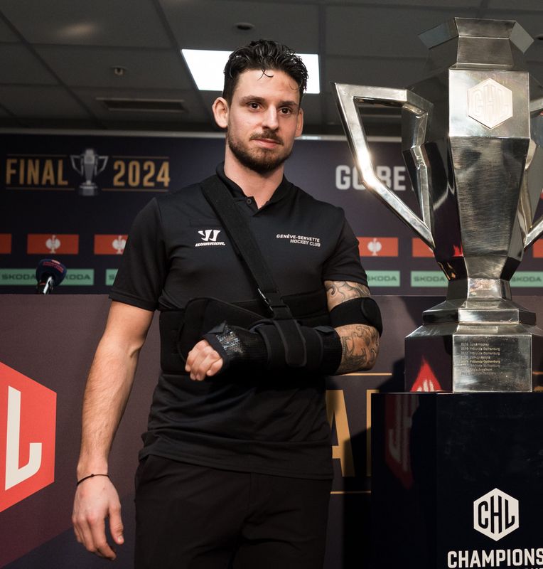 Le capitaine Noah Rod (GSHC) et l'entraîneur Jan Cadieux (GSHC) posent avec la coupe lors de la conférence de presse avant le match entre le Genève-Servette Hockey Club et Skelleftea AIK pour la finale de la Champions Hockey League, le 19 février 2024, au Stade de Genève.