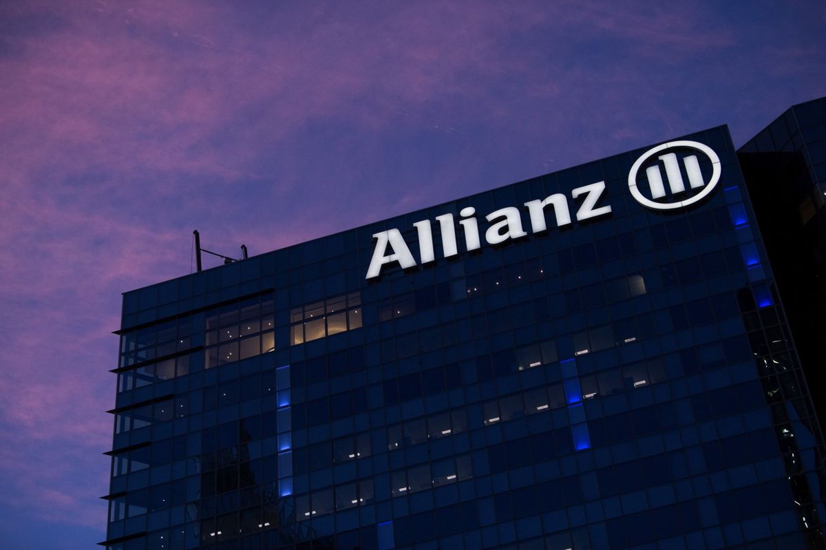 An illuminated Allianz SE logo on the company's offices at dawn in the La Defense business district in Paris, France, on Thursday, Jan. 21, 2021. The shift of jobs and assets to Paris after Brexit will accelerate this year, providing Europe with an opportunity to strengthen its own financial infrastructure, according to Bank of France Governor Francois Villeroy de Galhau. Photographer: Benjamin Girette/Bloomberg