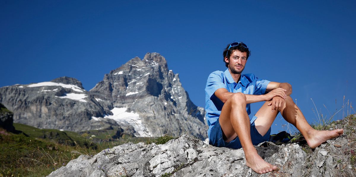 Kilian Jornet assis pieds nus sur un rocher devant le Cervin à Cervinia, Italie, le 20 août 2013.