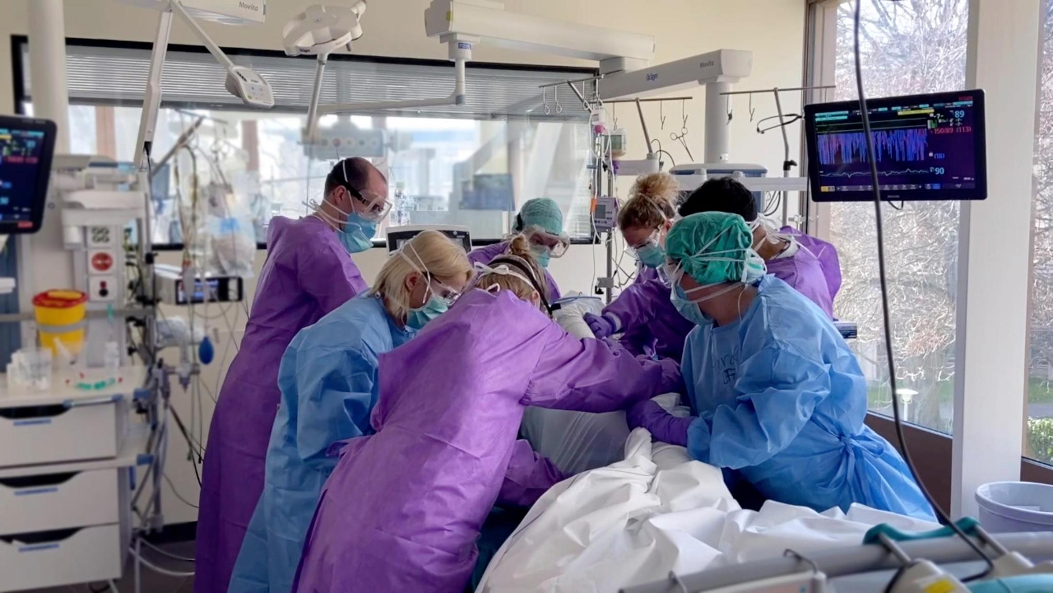 Sieben Personen sind nötig, um diesen Covid-Patienten umzulagern, damit sich keine Druckstellen bilden. Kein Schlauch darf verrutschen oder knicken, kein Sensor darf sich lösen.