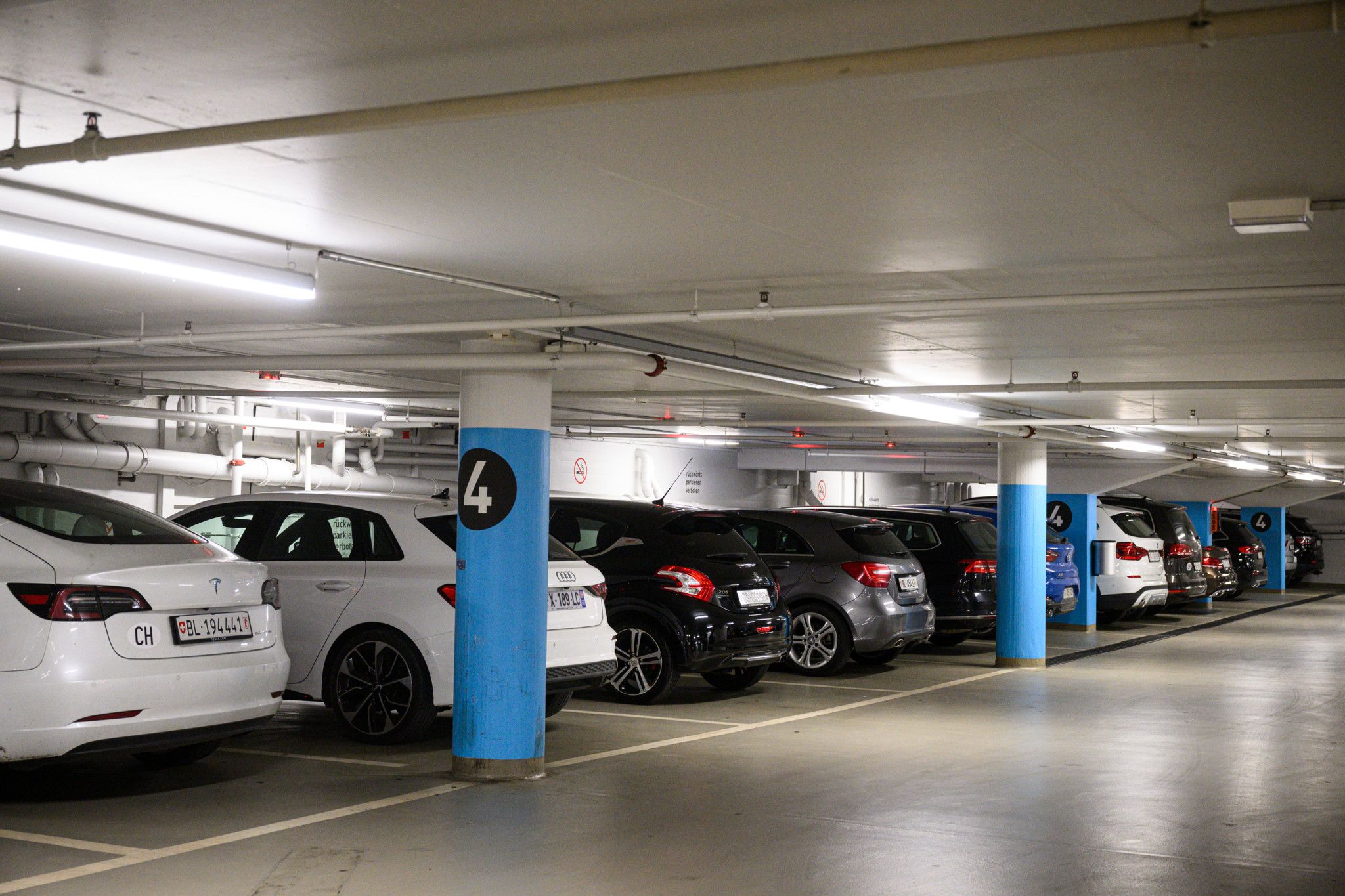 Enge Parksituation im Parkhaus Storchen in Basel: Mehrere Autos parken dicht an dicht auf Ebene 4.