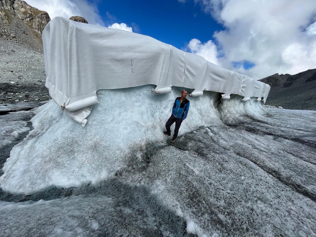 Le chercheur Christophe Lambiel devant la bâche qui protège un tronçon du glacier.