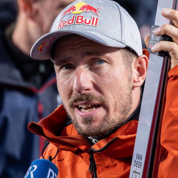 Skieur avec casquette et veste orange portant un trophée à Sölden, Autriche, lors du géant masculin.
