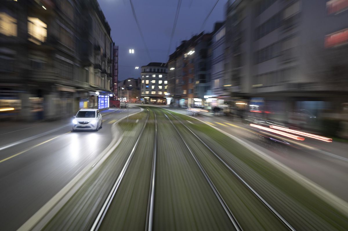 Ein weisses Auto faehrt auf der Badenerstrasse in der Nacht, fotografiert aus einem Tram mit laengerer Belichtungszeit am 25. November 2020 in Zuerich. (KEYSTONE/Gaetan Bally)