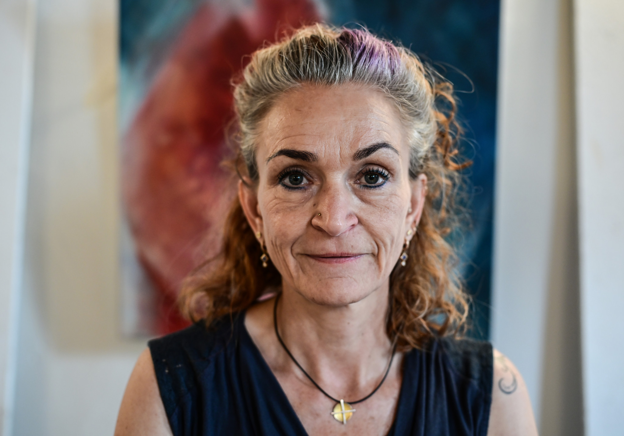Susanne Hübscher, Fachbereichsleiterin Psychosoziale Pflege bei der Spitex und Künstlerin, vor einem farbigen Gemälde.