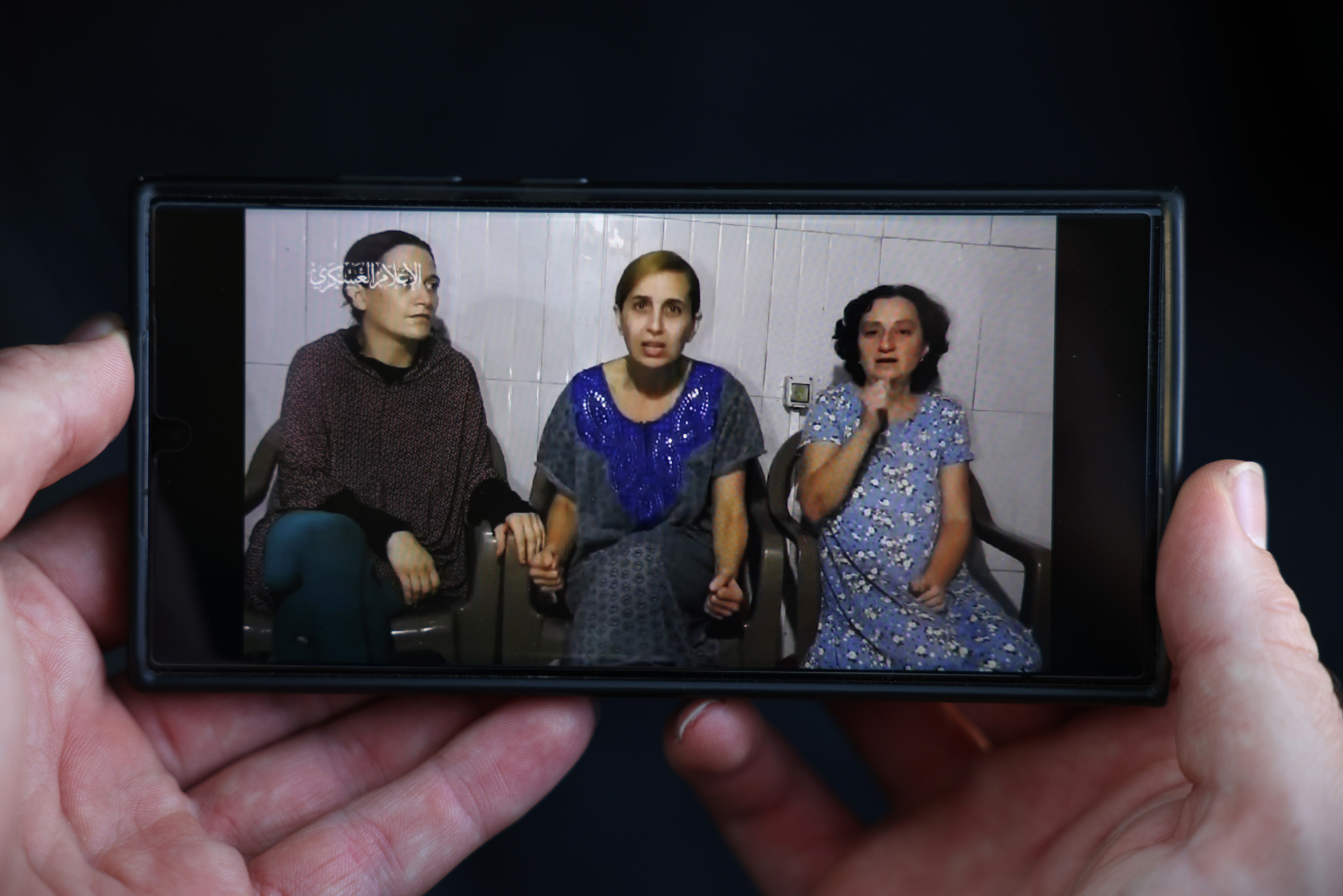 ISRAEL - OCTOBER 30: In this photo illustration, a phone displays footage released by Hamas today showing three hostages - (L-R) Rimon Buchshtab Kirsht (36), Danielle  Aloni (44), Lena Trupanov (50) - purportedly held in captivity in Gaza, on October 30, 2023. The identities of the three women were not immediately available. Hamas has demanded a prisoner exchanger for some of the hostages it has held since its Oct 7 attacks, which left an estimated 1,400 dead and 230 kidnapped, according to Israeli officials. The fate of those hostages has complicated the country's military response. Families of the victims worry that the military offensive may result in hostages being killed during Israeli bombing or from Hamas's reprisals. Some families and friends of hostages, who remain in Gaza, are calling on the government to trade for Palestinian prisoners. (Photo by Dan Kitwood/Getty Images)
