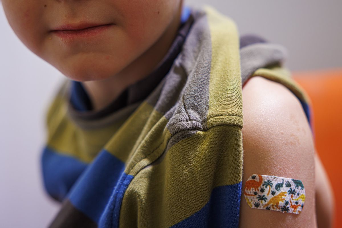 Un enfant est photographie apres avoir recu une dose de vaccin lors de la premiere journee ouverte a la vaccination contre le COVID-19 pour les enfants des 5 ans, ce samedi 8 janvier 2022 au centre de vaccination de la Chaux-de-Fonds. (KEYSTONE/Valentin Flauraud)...