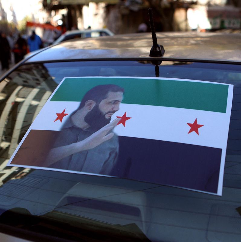 Un homme marche près d’un portrait de l’ex-président Bachar al-Assad au sol lors d’un rassemblement à la place Saadallah al-Jabiri à Alep, célébrant la fin du régime Baathiste.