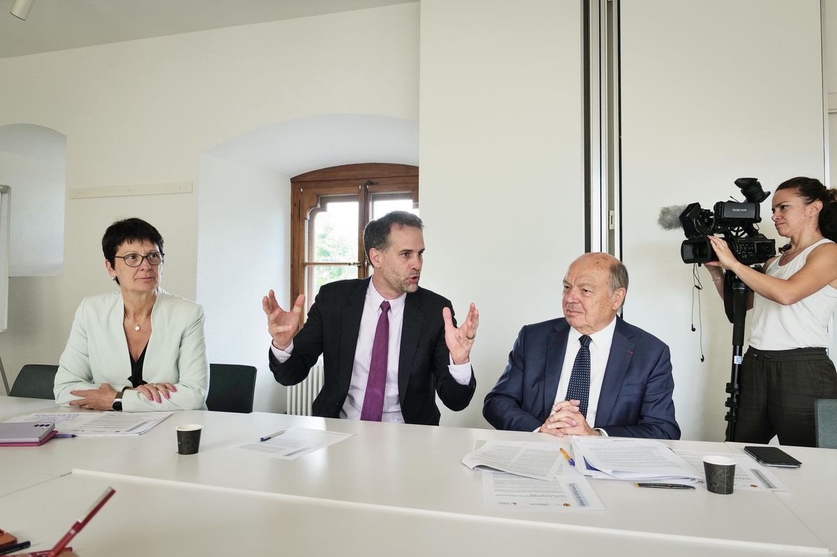 Trois responsables politiques discutent lors du vote de l’Assemblée du GLCT à Nyon, abordant la Vision territoriale transfrontalière pour le Grand Genève.