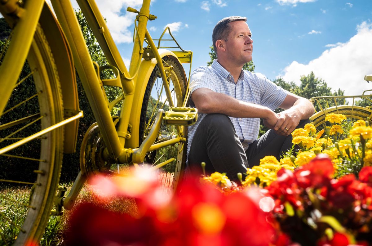 Grégory Devaud, syndic d’Aigle, pose devant un vélo repeint avec son fils, en vue du grand départ de la 9e étape du Tour de France dans sa ville.
.© Louis Dasselborne