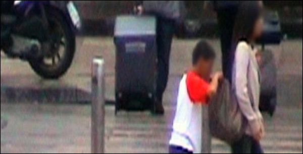 Ein Bub macht sich am Rucksack einer Passantin zu schaffen (Bild: SF)